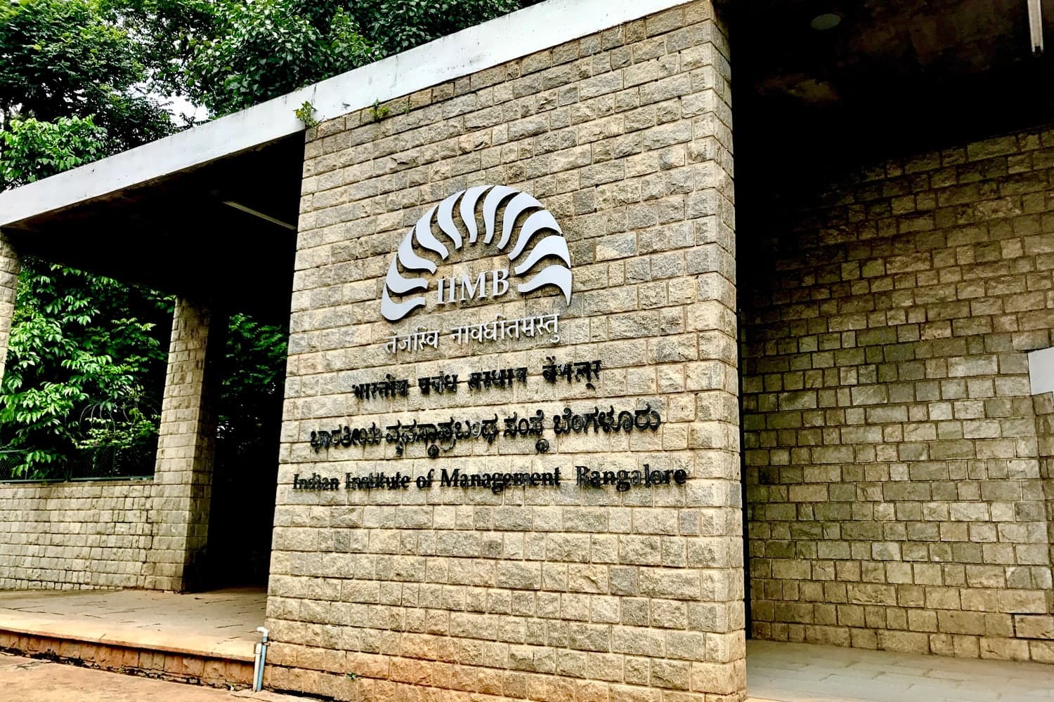 The IIM Bangalore name and emblem on the campus stone wall