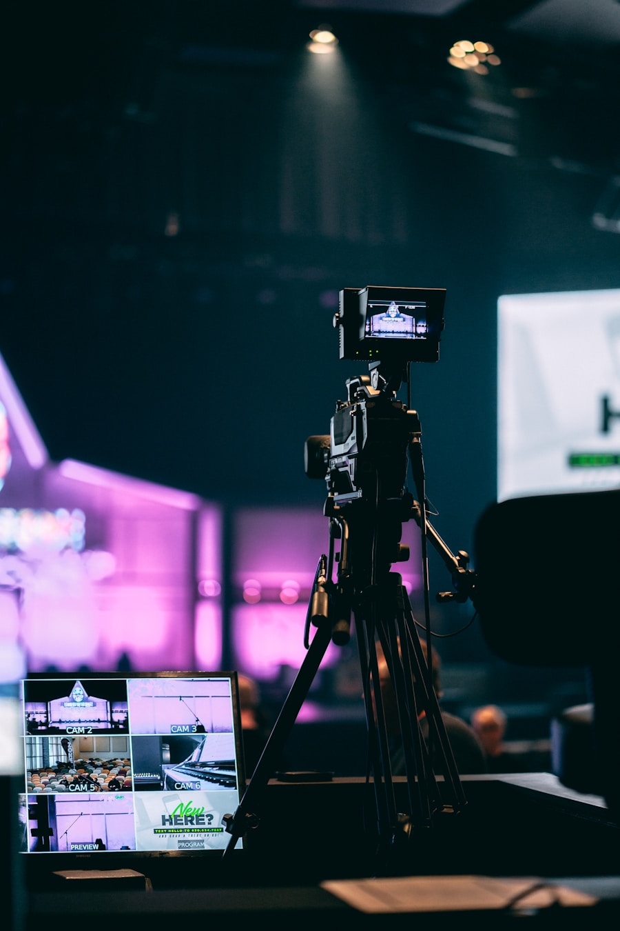 A camera on a tripod set up beside a laptop